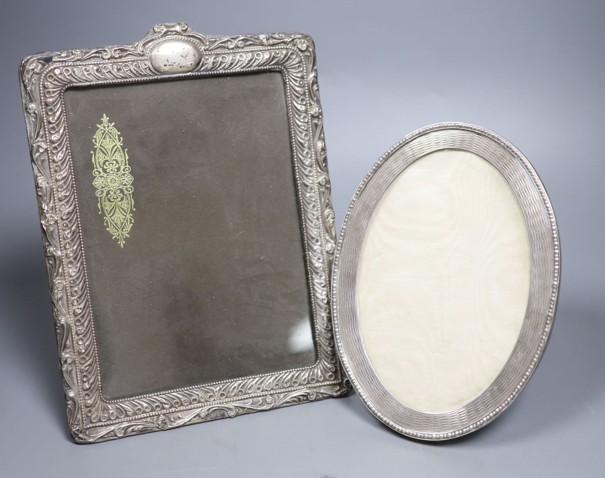 A George V oval silver photograph frame with reeded and beaded border, London 1910, 21.5cm and three other silver frames.